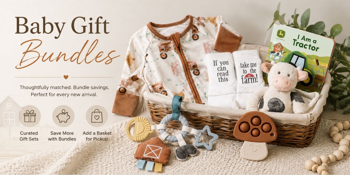 Baby gift bundle set in a wicker basket, featuring a cream and brown patterned baby romper, a white baby towel, a plush cow toy, a wooden mushroom toy, and a 'I Am a Tractor' book, displayed on a neutral textured background with promotional text.