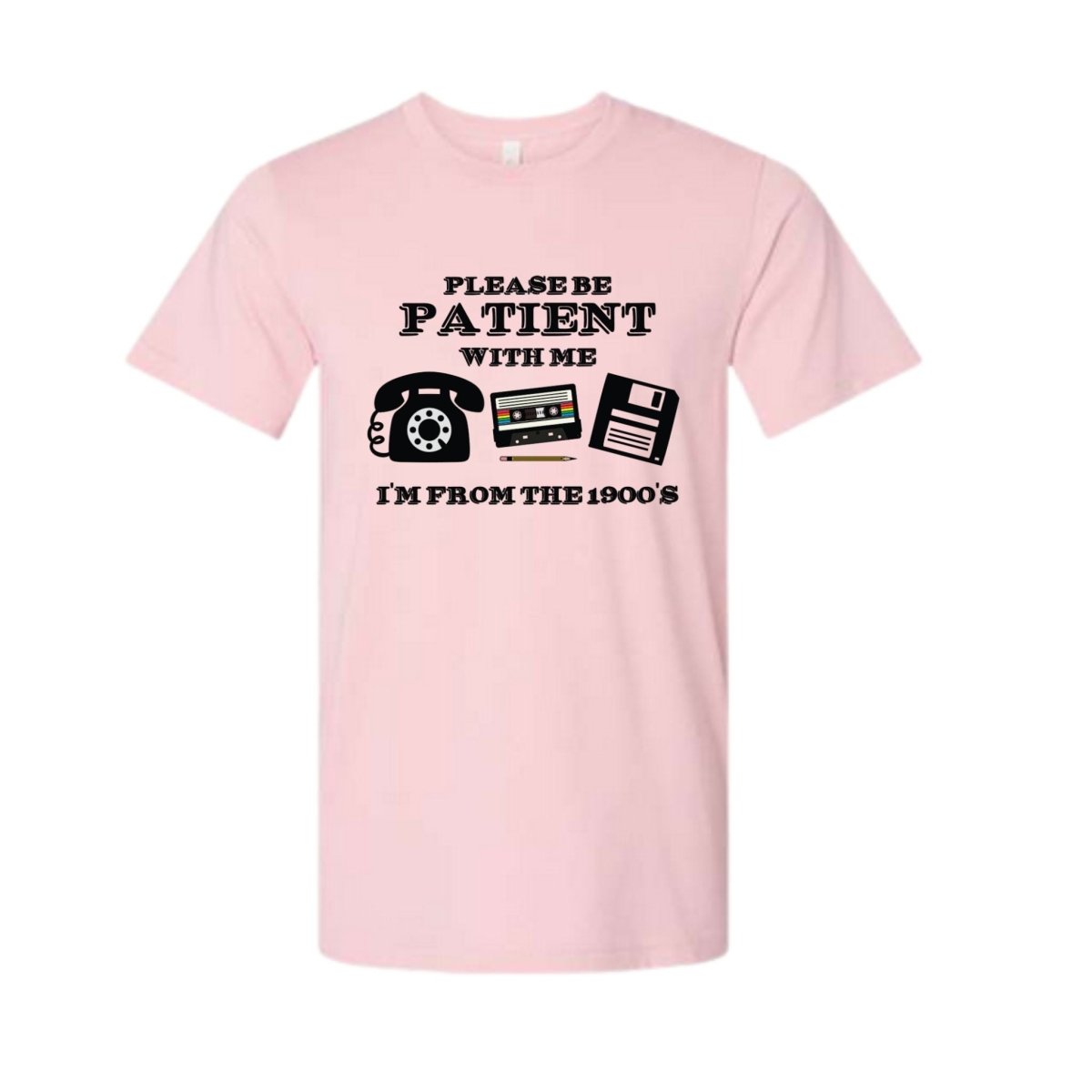 Pink tshirt with "Please be patient with me I'm from the 1900's" and old telephone, cassette tape, and floppy disc on front sitting on a white background. Little Gift Nook