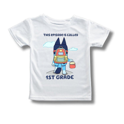 kids white blue dog back to school tshirt with "this episode is called 1st grade" on front on a gray background.