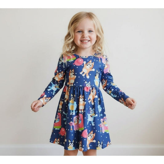 Little girl wearing blue long sleeve Bluey and Bingo theme twirl dress on gray background. Little Gift Nook