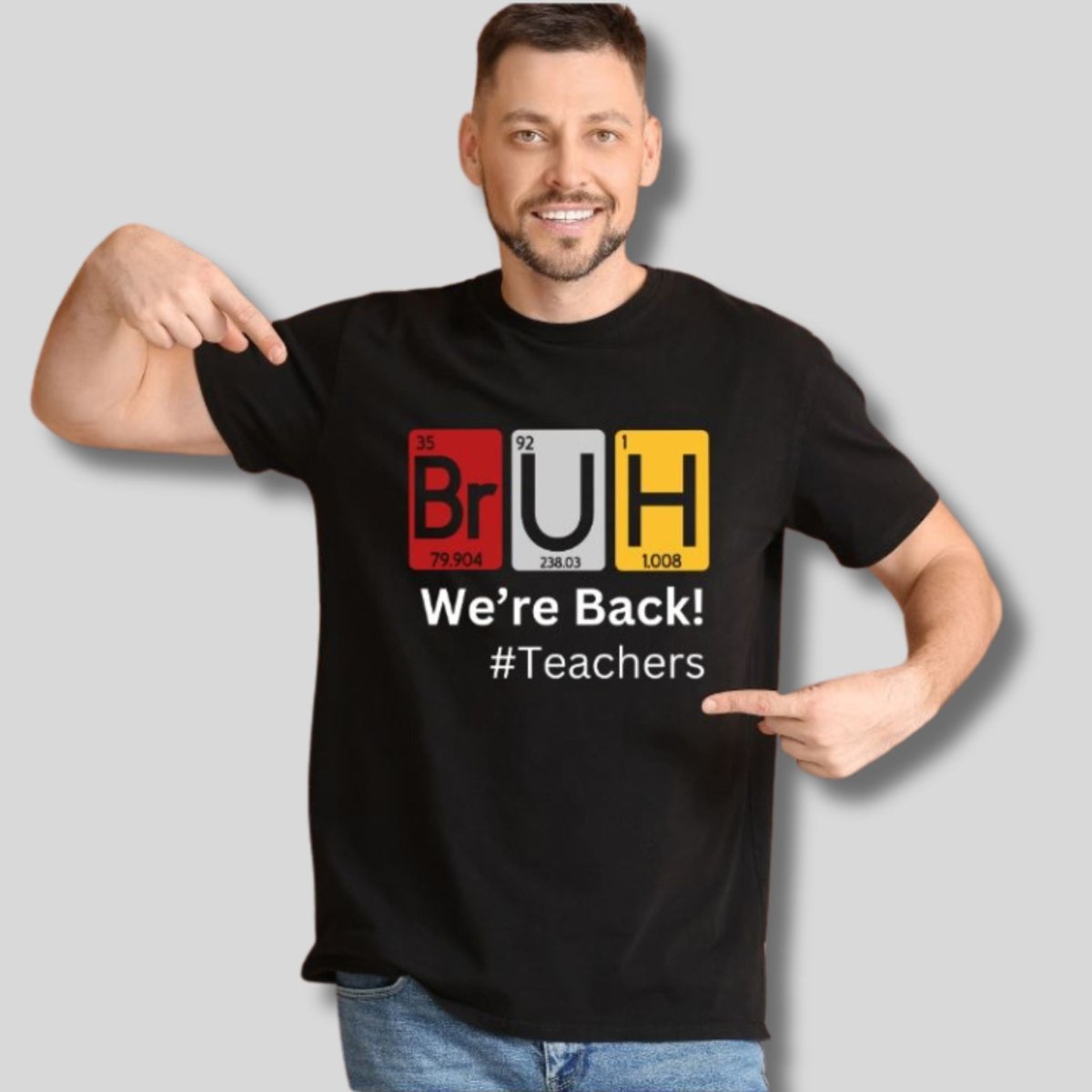 Man wearing black tshirt with BRUH science chemistry patriotic table and We're Back! #Teachers on front standing on a gray background.