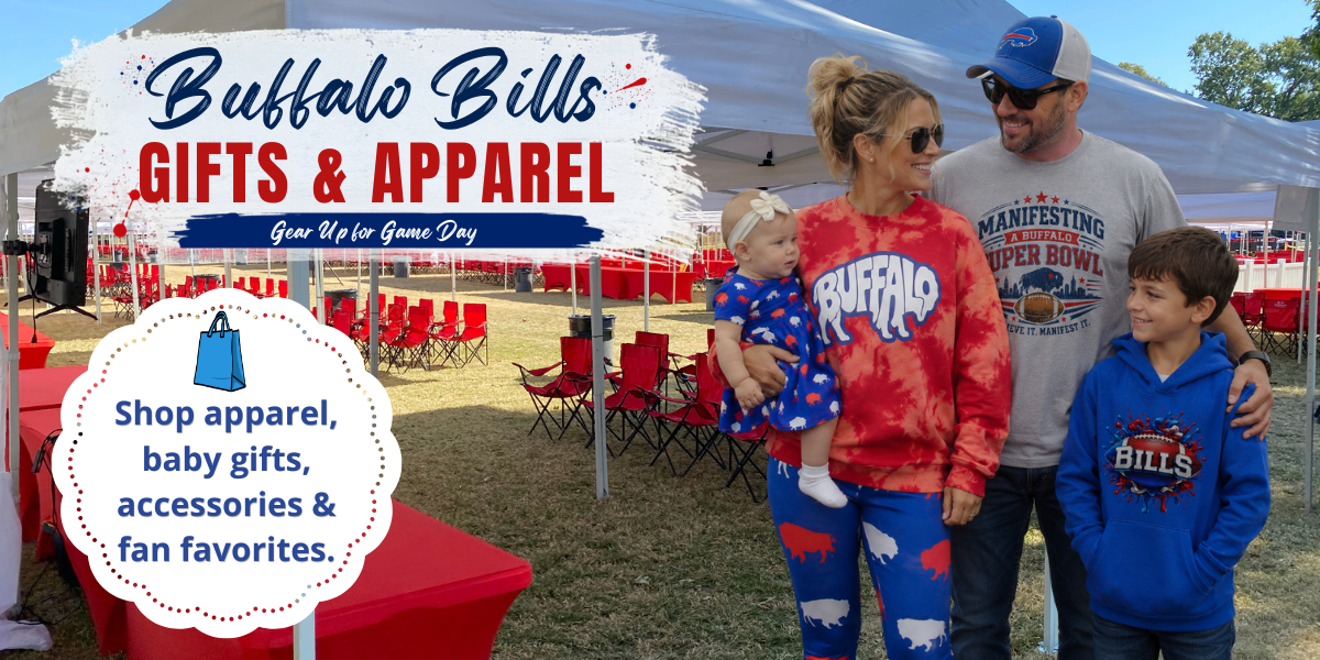 A family of four stands under a white canopy at an outdoor event, wearing Buffalo Bills themed apparel. The mother wears a red tie-dye Buffalo Bills sweatshirt and blue patterned pants, holding a baby in a matching red and blue outfit.