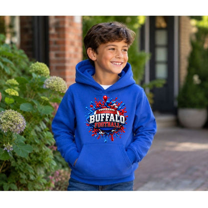 A young boy wearing a bright blue hoodie with a red, white, and blue 'Buffalo Football' graphic on the chest, standing outdoors in front of a house with green plants.