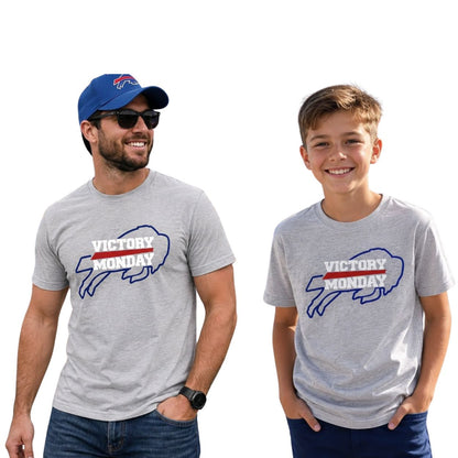 A man and a boy wearing matching heather gray t-shirts with a 'VICTORY MONDAY' buffalo graphic, shown against a plain white background.