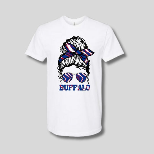 white tshirt with Buffalo red white blue messy bun in sunglasses image on front laying on gray background. Little Gift Nook