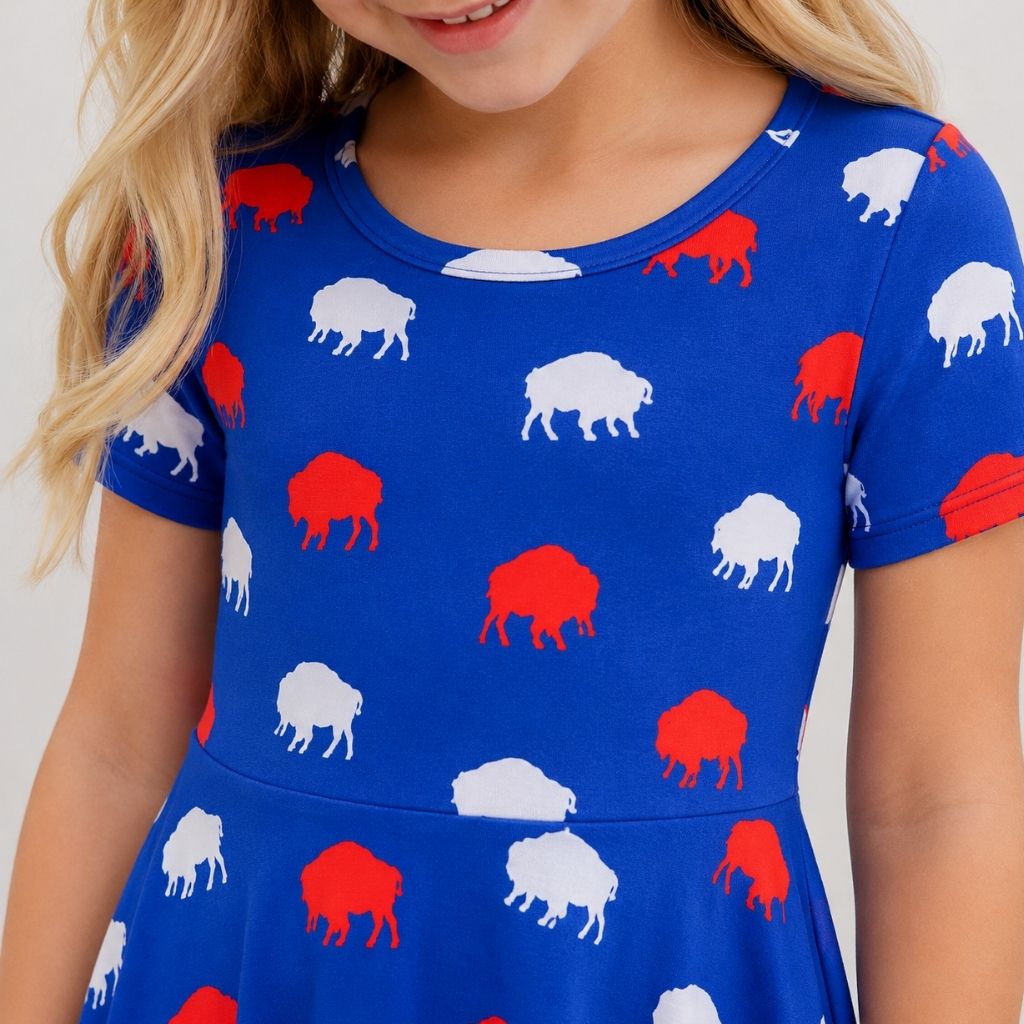 Close up of child wearing royal blue twirl dress with red and white buffalo silhouette print.