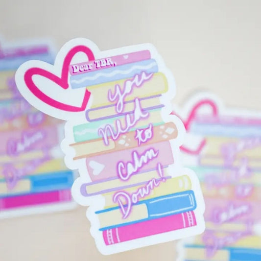 stack of books sticker with heart and "you need to calm down" on front on background of more stickers.