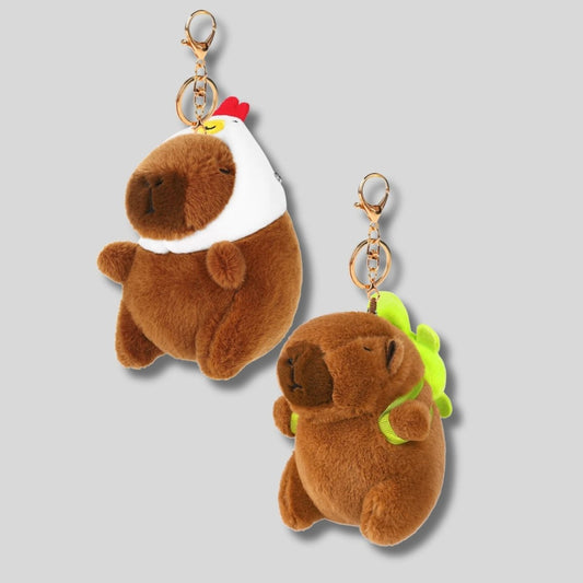 Capybara Keychain Plush Toys. Choose from a capybara wearing a chicken hat or wearing a turtle backpack.  Meaures 4.5" tall. Comes with keyring, clip, and adoption certificate. Little Gift Nook.