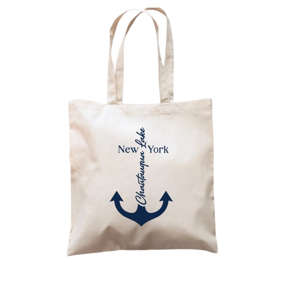 Beige tote bag with navy anchor and text design "Chautauqua Lake" on front.