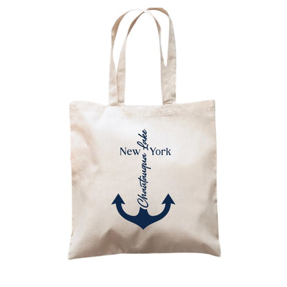 Beige tote bag with navy anchor and text design "Chautauqua Lake" on front.