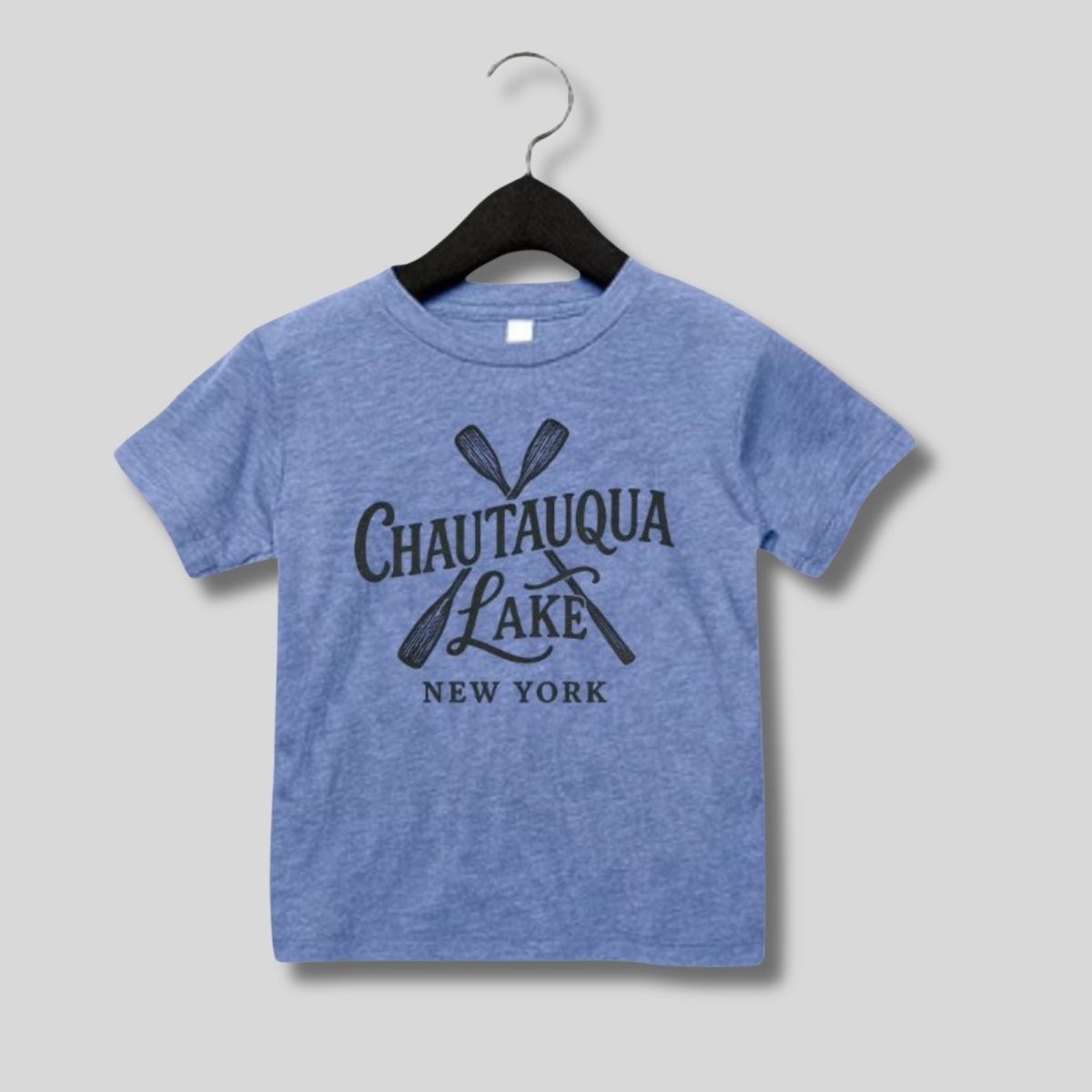 Blue child's Chautauqua Lake New York Paddles image tshirt hanging on light gray background.