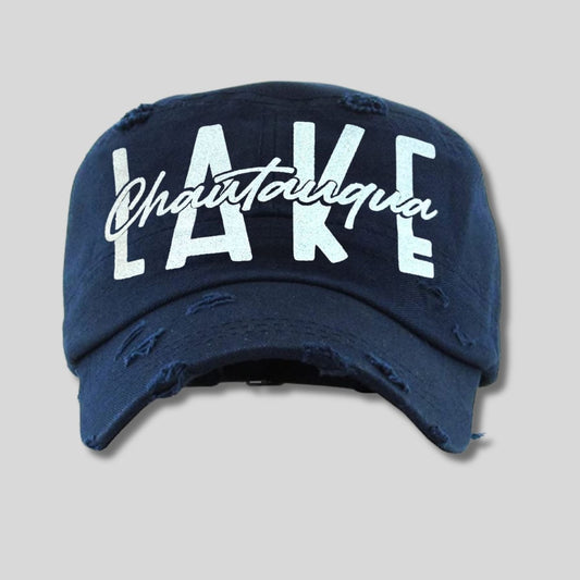 Lake Chautauqua navy cadet hat with white glitter font on front on gray background. Little Gift Nook