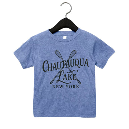 Blue child's tshirt with black "Chautauqua Lake New York" on front and sketched paddles sitting on a white background - Little Gift Nook