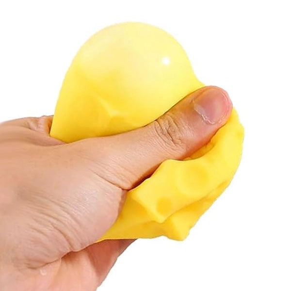 Hand squeezing cheese block sensory squish fidget toy on a white background.
