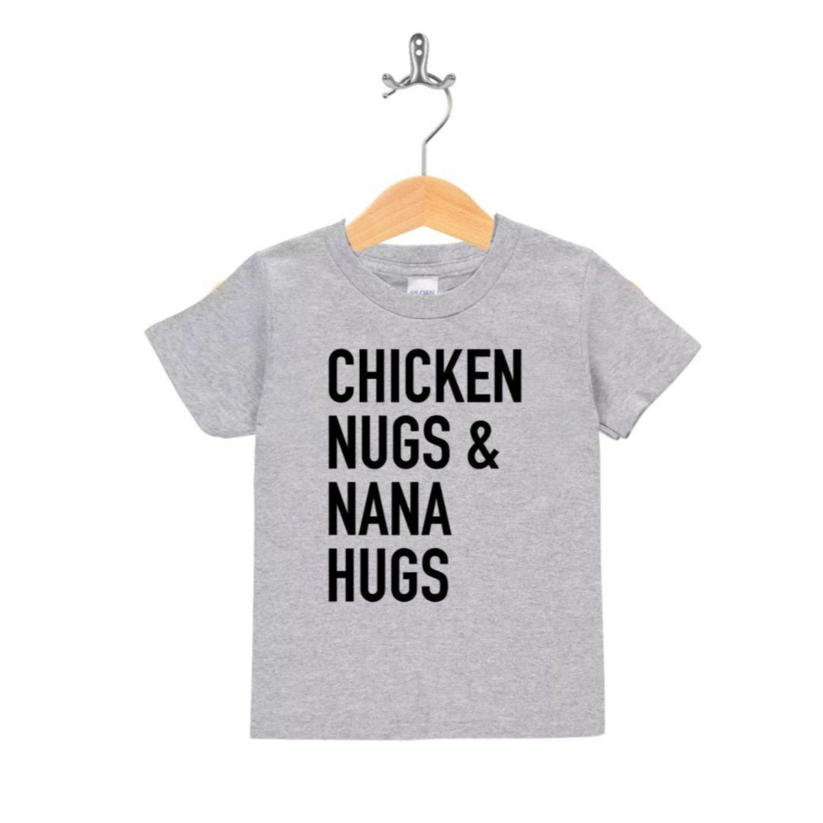 Heather gray kids tshirt with black text on front "Chicken nugs & nana hugs" hanging on wooden hanger on white background.