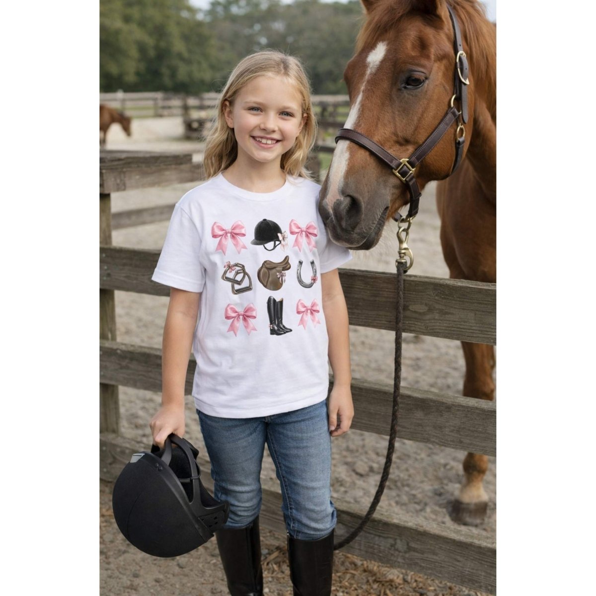 Young girl standing next to a horse, wearing a white t-shirt with horse-themed designs front. 