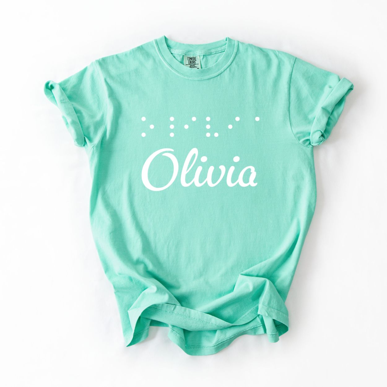 Mint t-shirt with custom name "Olivia" on front and name in Braille letters above in puffy raised vinyl.