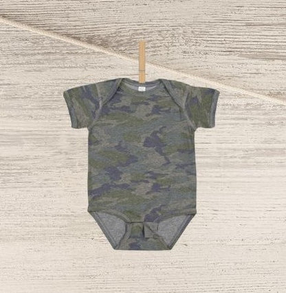 Blank green navy camo baby onesie personalized custom onesie hanging on clothespin n wood background.