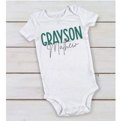 white personalized custom baby onesie with name in green gray on wood background