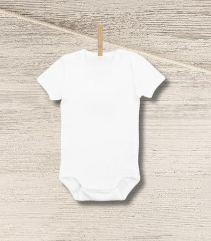 Blank white baby onesie personalized custom onesie hanging on clothespin n wood background.