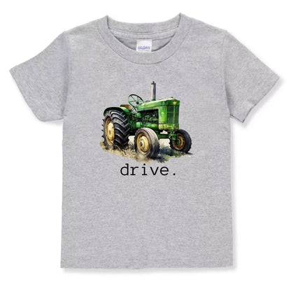 Gray toddler tshirt with green tractor and text "DRIVE" underneath it sitting on white background. 