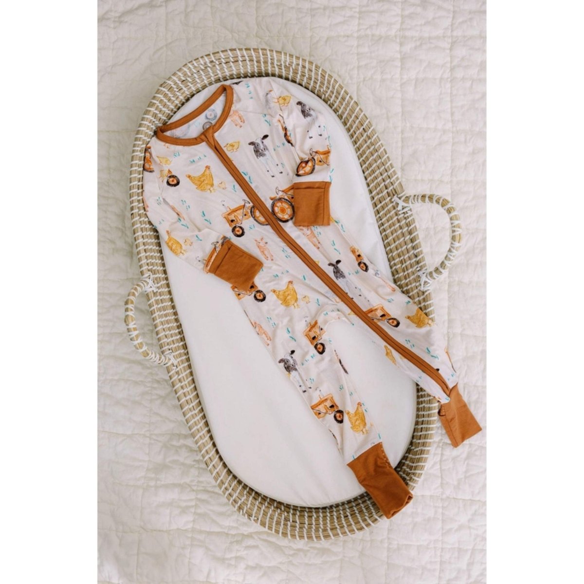 baby brown farm theme bamboo sleeper laying in bassinet. 