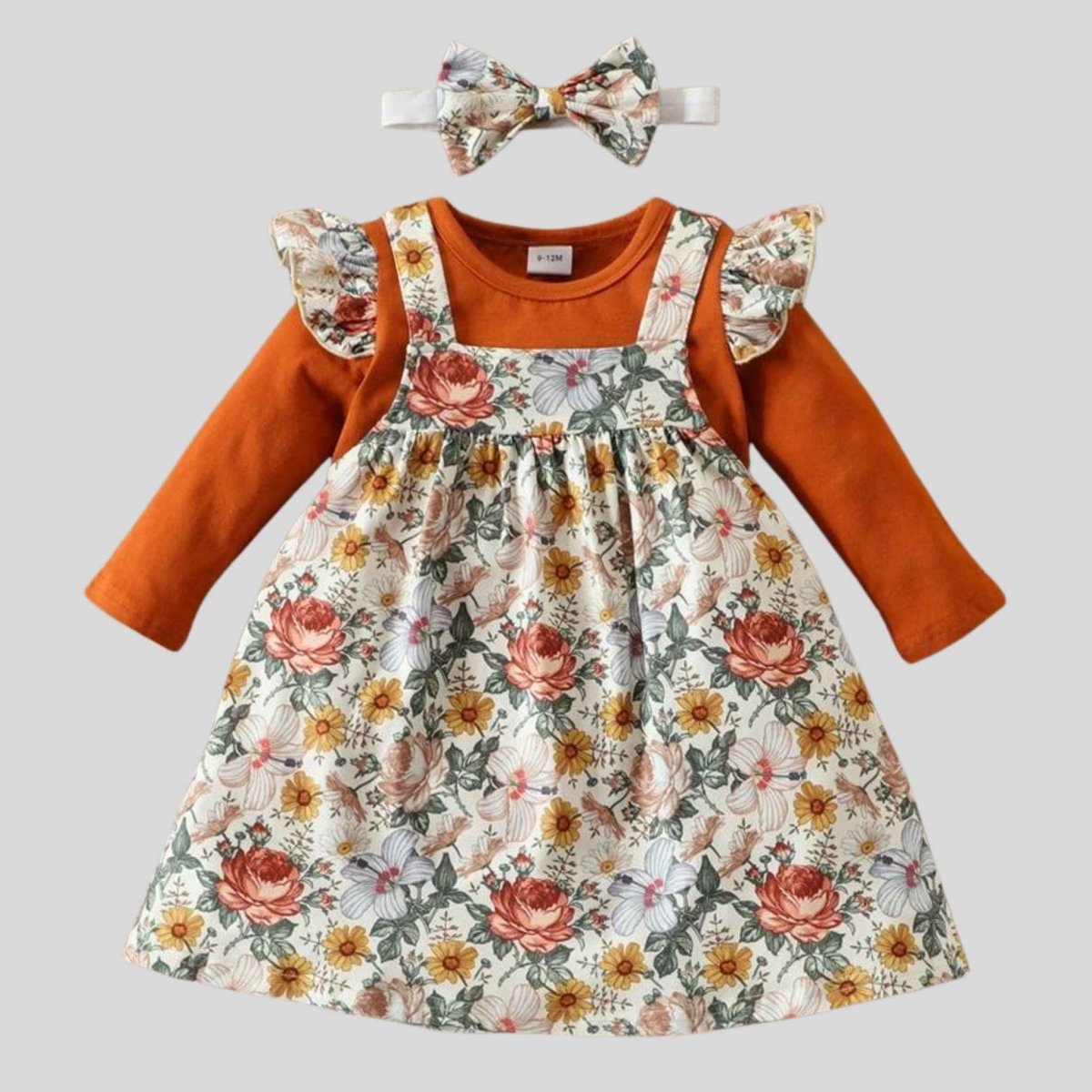 Floral Baby Girl 3pc Jumper Dress Set. Marigold, orange, white floral print with greenery soft jumper dress with orange long sleeve ruffle bodysuit for baby girl.  Bodysuit has same floral print ruffle accents at shoulders. Comes with matching floral hand band bow.- Little Gift Nook