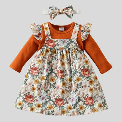 Floral Baby Girl 3pc Jumper Dress Set. Marigold, orange, white floral print with greenery soft jumper dress with orange long sleeve ruffle bodysuit for baby girl.  Bodysuit has same floral print ruffle accents at shoulders. Comes with matching floral hand band bow.- Little Gift Nook