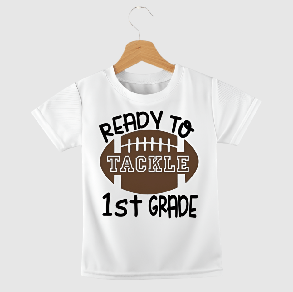 White tshirt with brown football and "Ready to tackle 1st Grade" on front. 