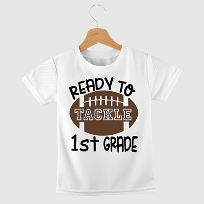 White tshirt with brown football and "Ready to tackle 1st Grade" on front. 