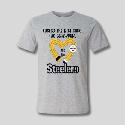 gray tshirt with yellow black pencil heart design and "fueled by diet coke, the classroom, and the Steelers" image on front. Little Gift Nook