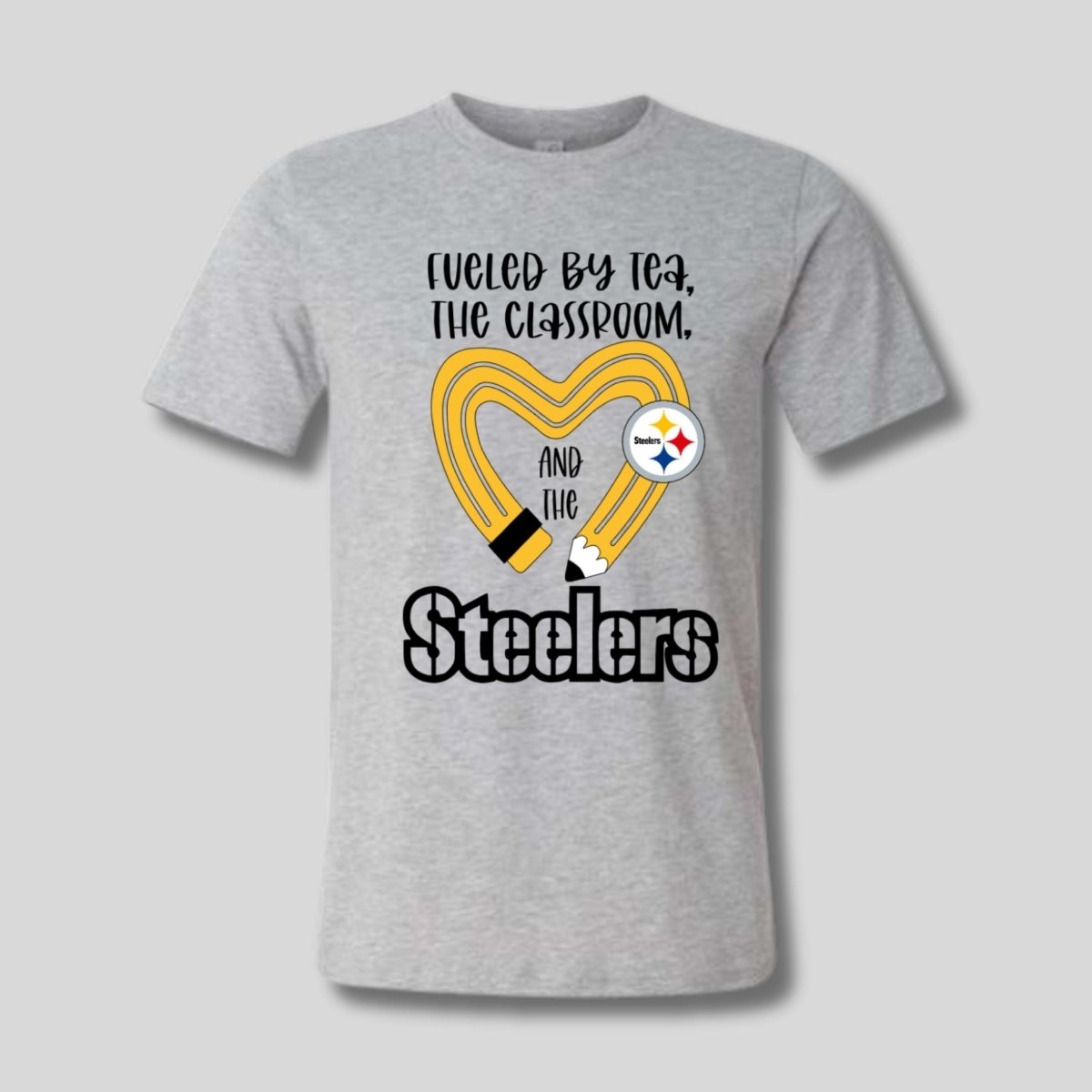 gray tshirt with yellow black pencil heart design and "fueled by tea, the classroom, and the Steelers" image on front. Little Gift Nook
