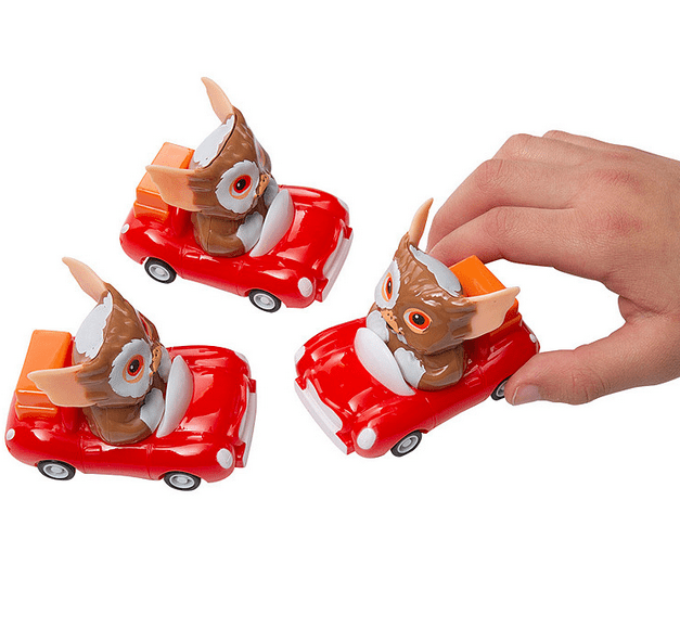 Mini Gizmo Gremlins pull back red car racer toys on white background and child's hand playing with toy.
