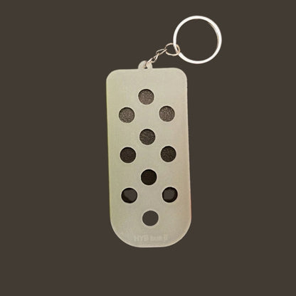 Shoe charm keychain clear plastic glows in the dark on metal keyring on gray background. 