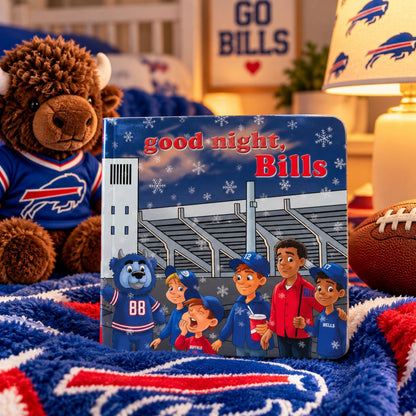 A children's board book titled 'good night, Bills' is displayed on a blue and red buffalo-themed blanket in a cozy bedroom setting. The book features cartoon characters and a stadium scene, surrounded by a plush buffalo toy, a football, and a lamp with Buffalo Bills branding.