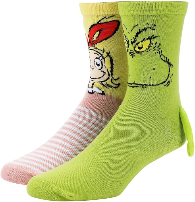 Magnetic hand holding Grinch and Cindy Lou woman's socks on feet standing on white background. 