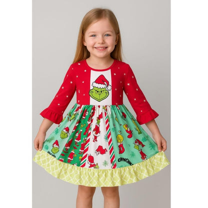 Little girl wearing red and green Grinch theme twirl dress on gray background. 