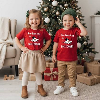 Kids wearing red I'm having a meltdown snowman tshirts standing in front of Christmas tree. Little Gift Nook