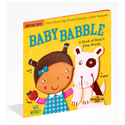Indestructibles baby book "Baby Babble" yellow cover book with girl and dog sitting on white background.