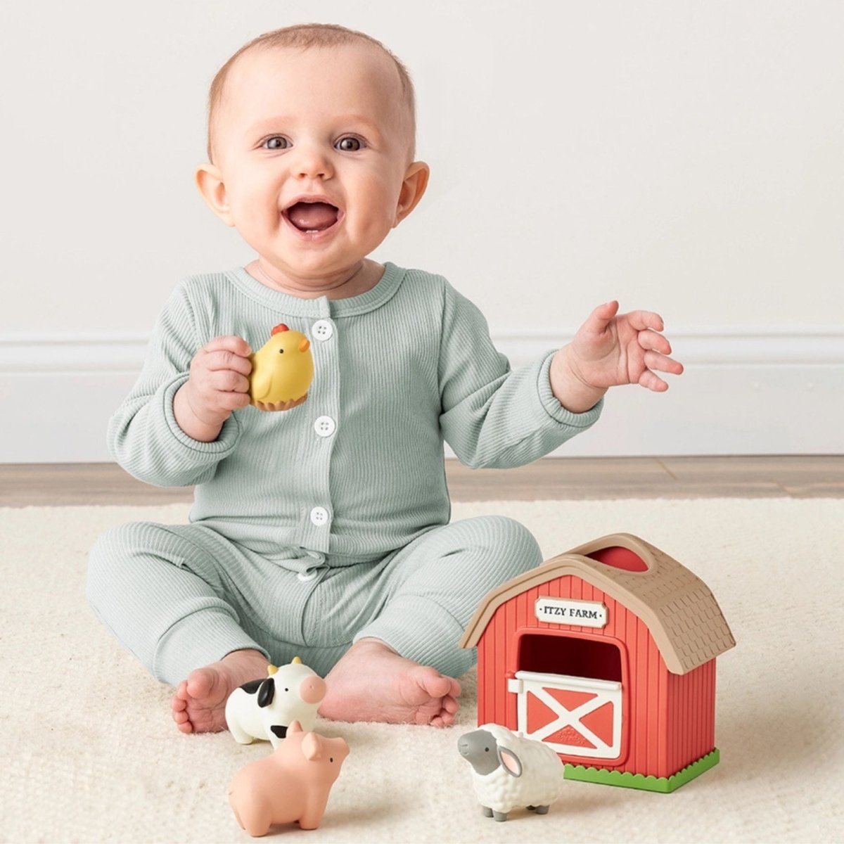 Baby playing with Red plastic barn with little cow, pig, sheep, and chicken playset.