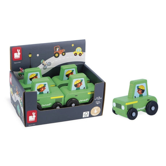 Green wooden toy tractor by Janod sitting on white background with display box of 4 more tractors. 