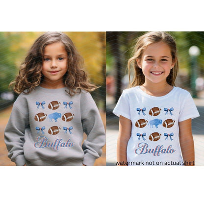little girls wearing heather gray swatshirt or white tshirt with blue bows, buffalo, and brown footballs with the text "Buffalo"in blue and red cursive  below image on fronts.