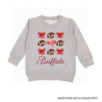 heather gray sweatshirt with red bows, buffalo, and brown footballs with the text Buffalo in red and blue cursive below image on front.