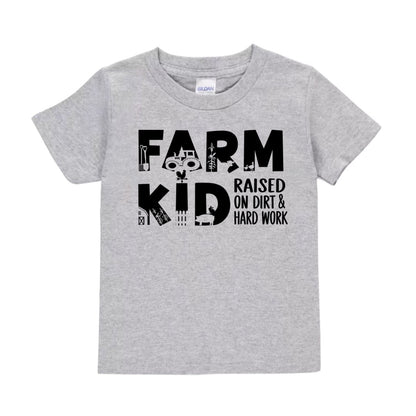 Gray kids Farm Kid Raised on dirt & hard work" tshirt sitting on white background.