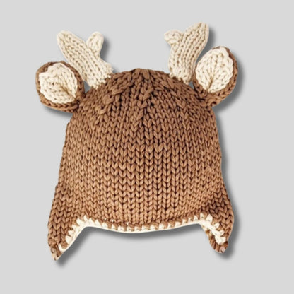 Buck Deer Beanie Knit Baby Hat. Soft yarn and trimmed with adorable antlers and little ear flaps. Cute baby gift. Shown on gray background.  Little Gift Nook.