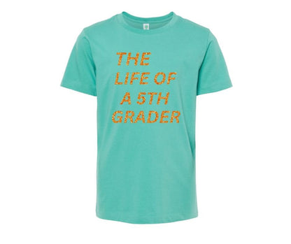 Seafoam Teal Green youth tshirt with orange glitter "Life of a 5th Grader" Tshirt on white background.