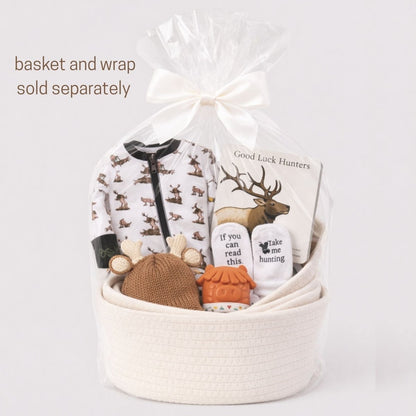 Gift basket with hunting baby gifts packed up with cellophane and white bow on a gray background. 