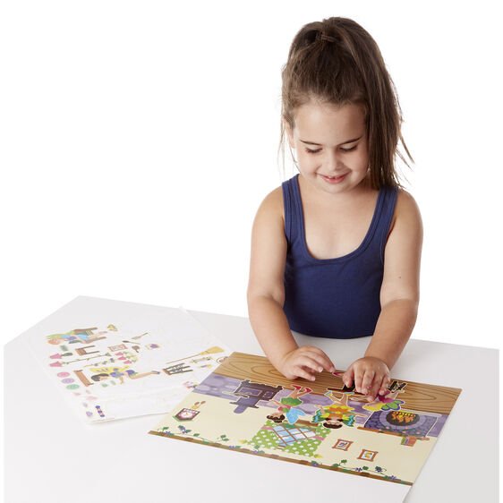 Little girl playing with Melissa & Doug reusable fairies sticker pad on white background.