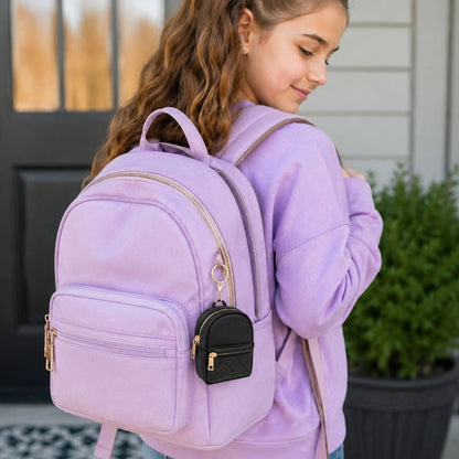Girl wearing purple hoodie and backpack with mini keychain backpack clipped onto it.