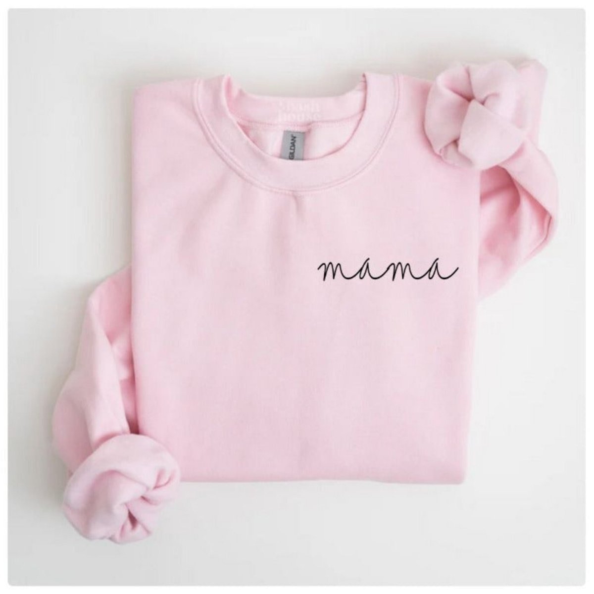 Pink crewneck sweatshirt, folded, with rolled up sleeves with black mama print on left chest on a white background. Little Gift Nook